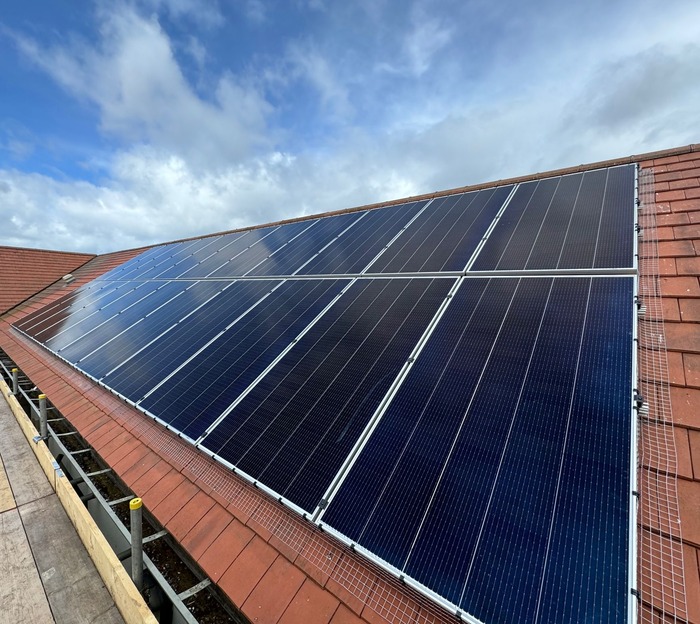 Pigeon proofed solar panels with mesh attached on a red tiled roof