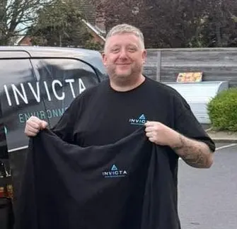 Pest Control Technician Gareth holding uniform next to Invicta van