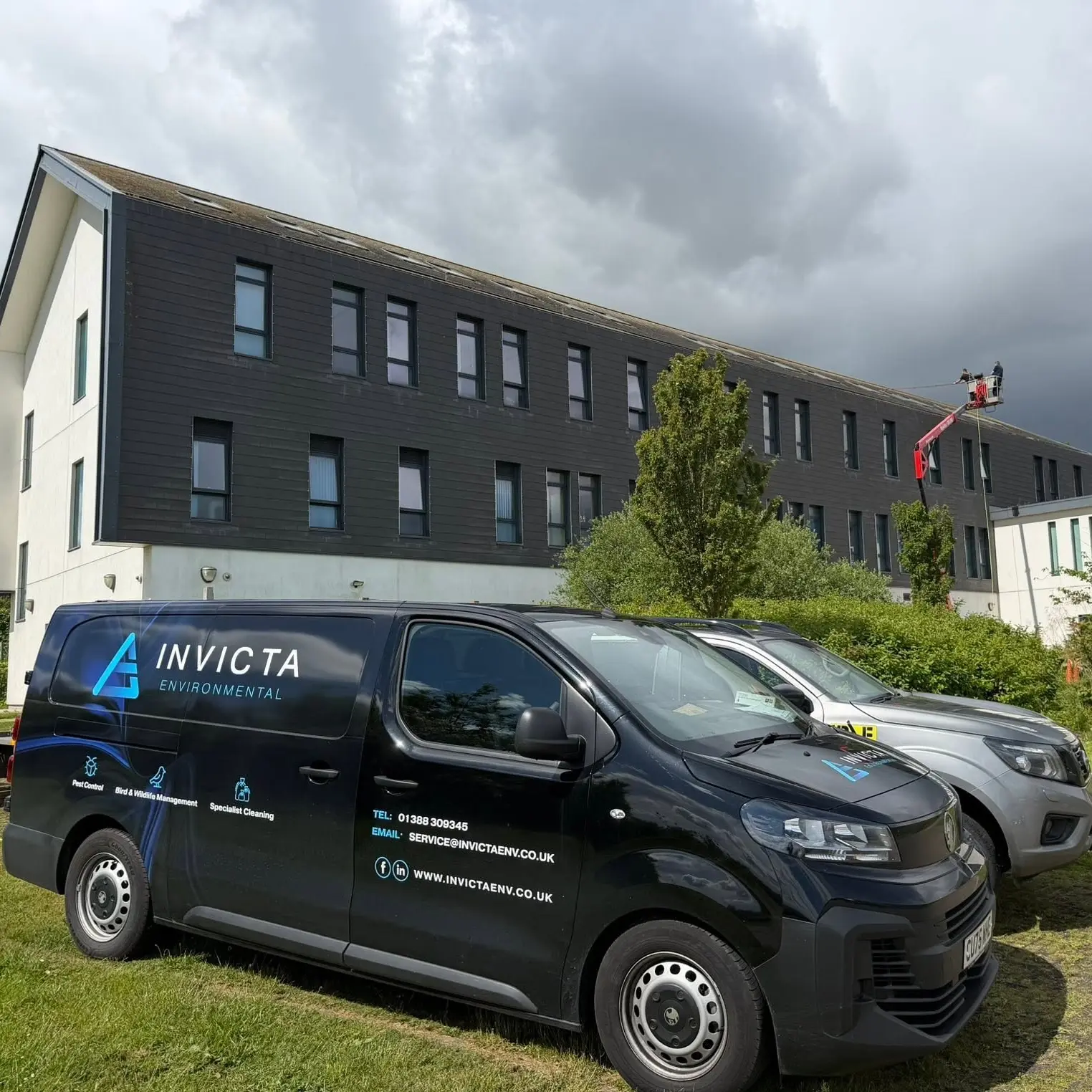 Invicta branded vans in front of a building